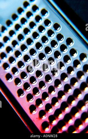 Close up abstract macro detail of a chrome metal food grater Stock Photo