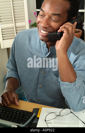 Man talking on phone in home office. Stock Photo
