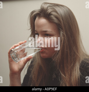 European girl drinking water from a clear glass Stock Photo
