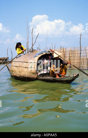 Fisherwomen in boat on Tonle Sap Lake Cambodia because of reverse flow of Mekong River Lake size fluctuates so fishing village Stock Photo
