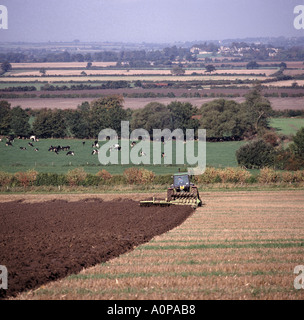 John Deere tractor ploughing stubble field with reversible coulter plough Oxfordshire Stock Photo