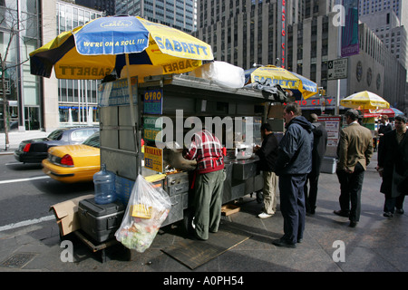 Typical New York City street food vendors feed crowds of office workers at lunch time NYC USA America Stock Photo