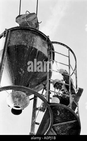 Concrete Bucket With Its Operator Suspended On End Of Crane Stock Photo