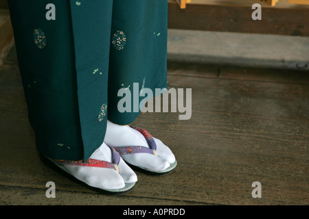 Closeup of a Japanese woman wearing a traditional dark green silk kimono with white tabby socks and ancient sandals visit Kyoto Stock Photo