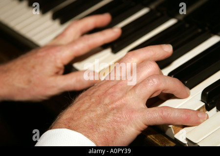 close up of old man hands playing the piano Stock Photo