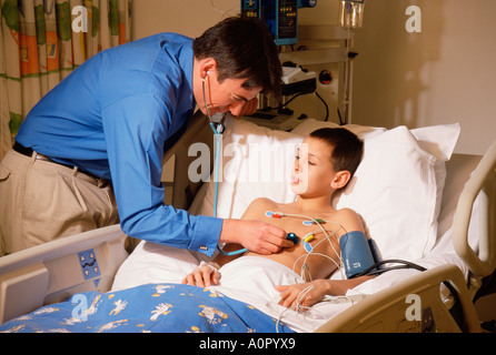 Hospital. Paediatrics. Paediatrician. Intensive care doctor at bedside of young boy patient. Stock Photo