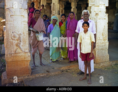 Group of women man & boy in colourful traditional clothing looking after ancient temples Hampi Karnataka India South Asia Stock Photo