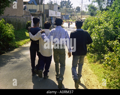 Group of blood friend men walking around leaning on each other Udhagamandalam Ootacamund Ooty Tamil Nadu India South Asia Stock Photo
