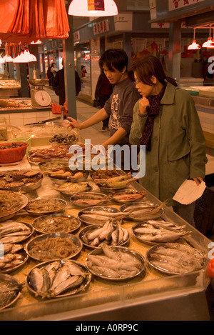 dh Tai Po indoor Market TAIPO WET MARKETS HONG KONG NT Woman Fish stall shop customer fishmonger chinese choosing food shopping China Stock Photo