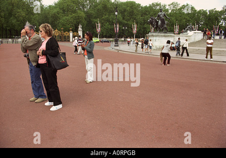 ENGLAND LONDON Tourists taking photographs outside Buckingham Palace