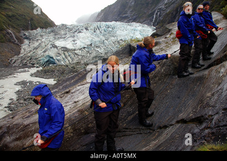 Ecotourists descending from a walk on Franz Joseph glacier Westland National Park New Zealand No MR Stock Photo