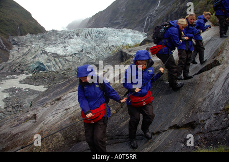 Ecotourists descending from Franz Joseph glacier Westland National Park New Zealand No MR Stock Photo