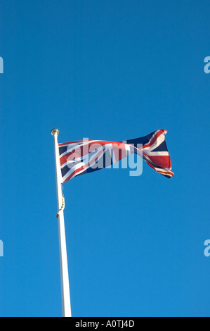 The British Union Jack flag flies proudly against a blue sky in the city of Portsmouth on the South Coast of England Stock Photo