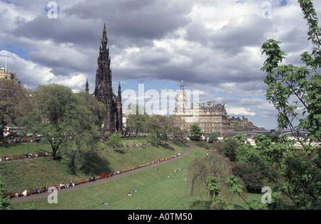 City of Edinburgh general view of people relaxing in garden areas beside Princes Street with Scott memorial beyond Stock Photo