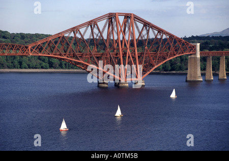 Three sailing boats & part of famous historical Victorian Scottish Firth of Forth steel cantilever rail bridge South Queensferry shoreline Scotland UK Stock Photo