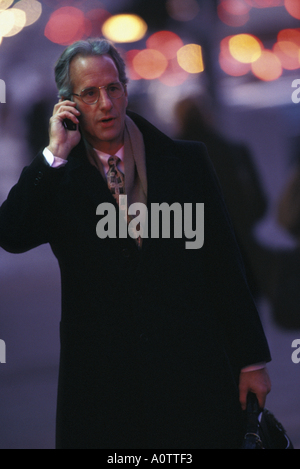 Caucasian Businessman talking on cel phone in the evening, on the street Stock Photo