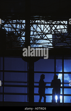 Silhouetted  Male and female business executives networking in an office building atrium so Stock Photo