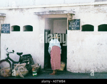 AFRICA MOROCCO TANGIER Moroccan Berber woman in traditional dress entering women s public restroom, signs in Arabic French Stock Photo