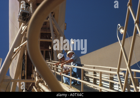 Engineers on elevated catwalk at wind turbine structure. Palm Springs, Ca, USA Stock Photo