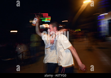 Ayia Napa, Cyprus. British tourists with bottle of alcohol in the street, inebriated, at about 1am, town centre Stock Photo