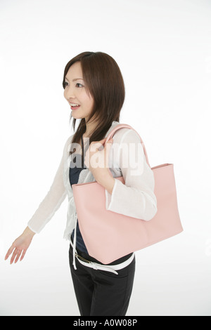 Side profile of a young woman carrying a purse Stock Photo