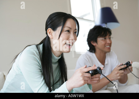 Young couple playing a video game and smiling Stock Photo