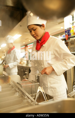 Female chef cooking food in the kitchen Stock Photo