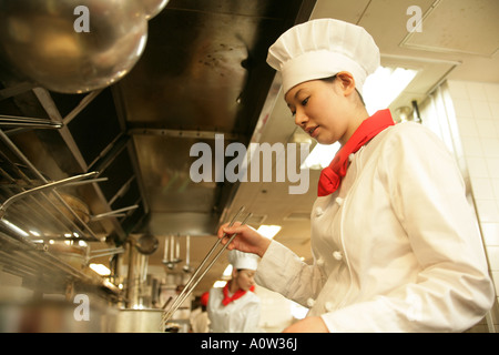 Side profile of a female chef cooking in the kitchen Stock Photo