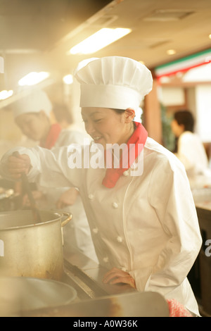 Female chef cooking in the kitchen Stock Photo