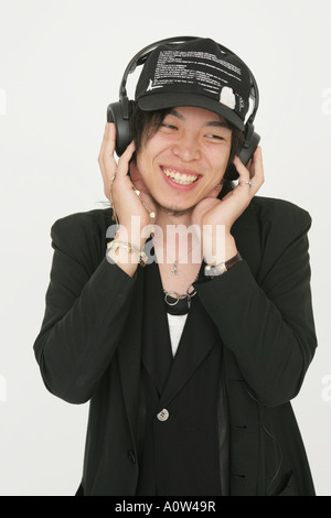 Close up of a young man listening to music and smiling Stock Photo