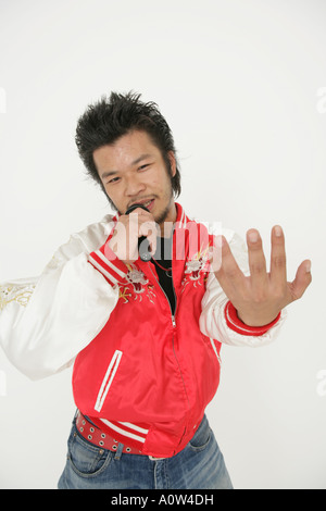 Portrait of a young man singing on a microphone Stock Photo