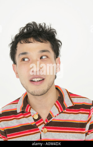 Close up of a young man looking sideways and smiling Stock Photo
