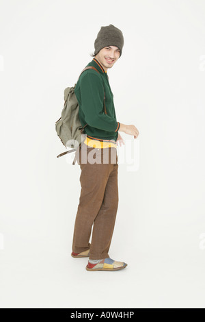 Portrait of a young man carrying a backpack and smiling Stock Photo