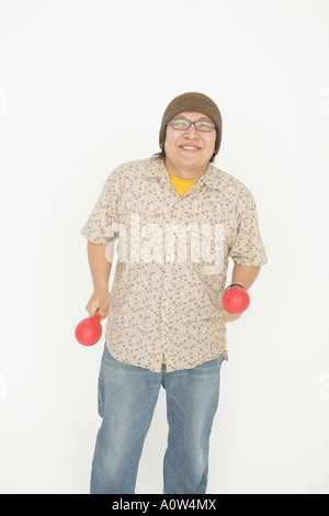 Portrait of a mid adult man holding maracas and smiling Stock Photo