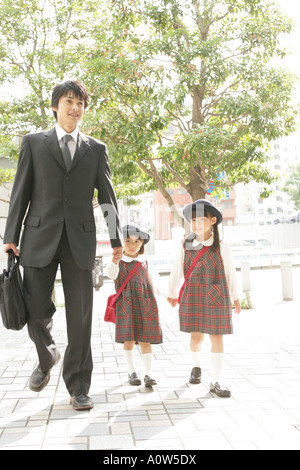 Mid adult man holding his daughters hand and walking Stock Photo