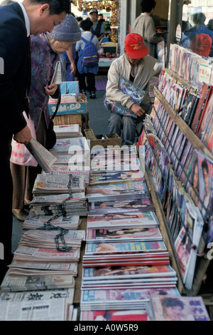 People look at Chinese newspapers and magazines at news agents display Chinatown San Francisco California Stock Photo