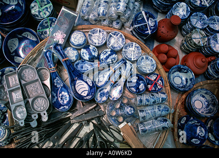 Chinese made patterned blue and white ceramic ware and other items for sale on a vendors stall at market Hoi An Vietnam Stock Photo