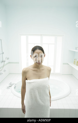 Cheerful asian woman wrapped in towel touching her face Stock Photo - Alamy