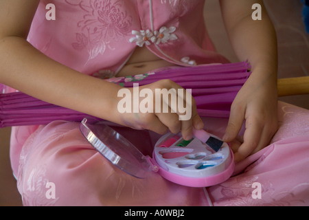 Little girl making up herself on the balcony Stock Photo