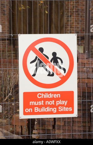 A warning sign on wire fence. Building site notice. Children must not play on building sites. UK. Stock Photo