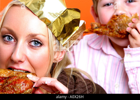 Mother and Son Eating Turkey Drumsticks Models Released Stock Photo