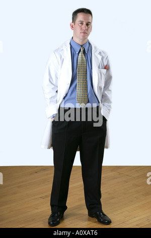 Male doctor portrait with a white lab coat standing with his hands in his pocket. Stock Photo