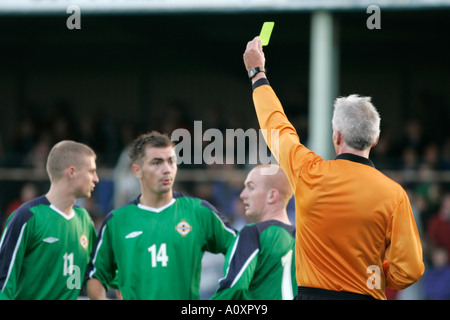 The referee hands out a yellow caution card to northern ireland players Northern Ireland v USA Northern Ireland Milk Cup Stock Photo