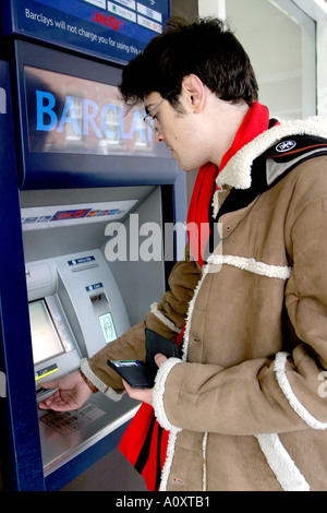 Young Male Using Cash Machine Stock Photo