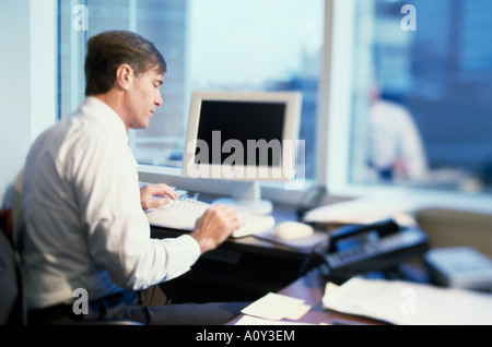 Side profile of a businessman working on a computer Stock Photo