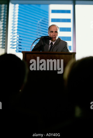 Businessman giving a speech at a podium Stock Photo