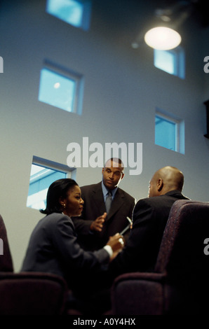 Low angle view of a businesswoman and two businessmen in a meeting Stock Photo