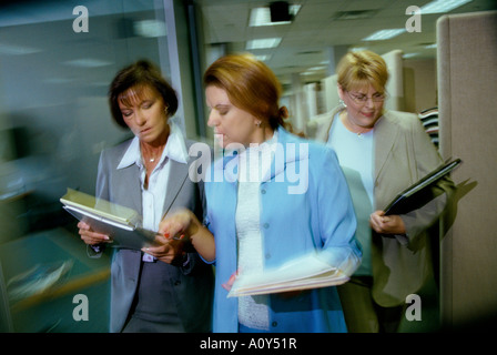 Three businesswomen walking in an office Stock Photo