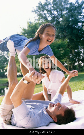 Father balancing his daughter on his feet Stock Photo