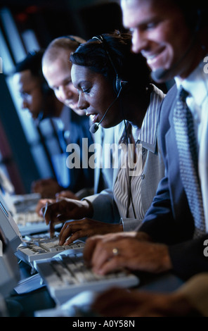 Side profile of five customer service representatives working in an office Stock Photo